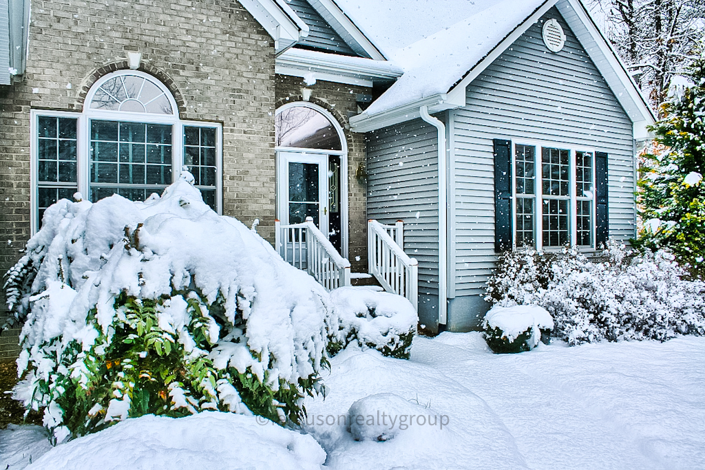 snow on a house with snow on shrubs