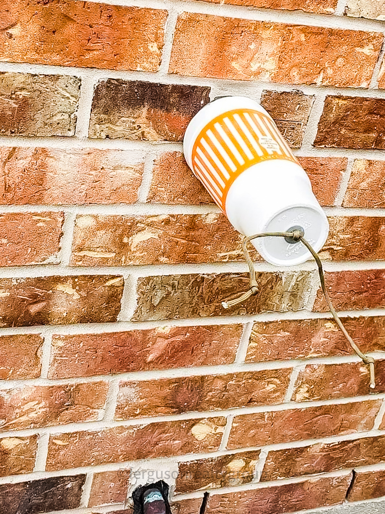 whatburger cup insulating water valve on brick wall